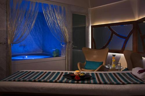 a bedroom with a bed and a tub in a room at Renaissance Izmir Hotel in Izmir