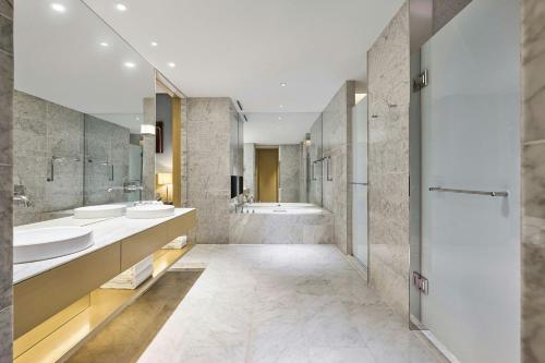 a large bathroom with two sinks and a tub at Le Meridien Taipei in Taipei