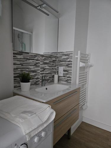 une salle de bain avec un lavabo et un miroir dans l'établissement West Side Story - Wifi ,City center, à Beaupréau