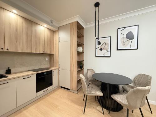 a kitchen with a table and chairs in a room at Apartamenty Klonova Park in Olecko