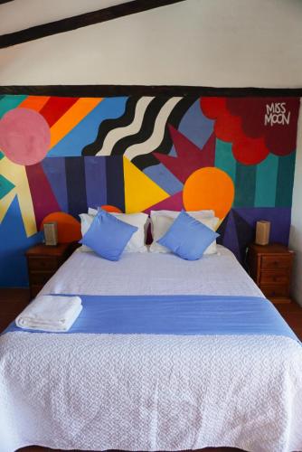 a bedroom with a large bed with a colorful wall at Samariwasi Airport hotel in Yaruqui