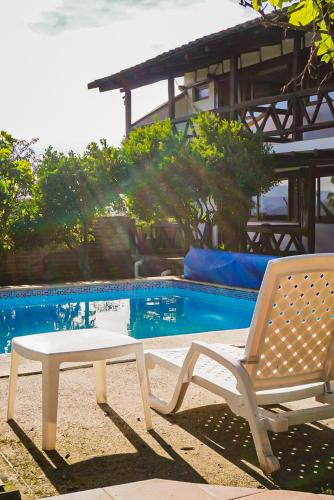 a table and a chair next to a swimming pool at Samariwasi Airport hotel in Yaruqui