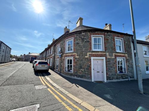 a brick building with a car parked on a street at The Round House in Strangford