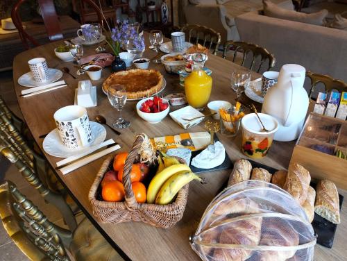 una mesa de madera con un montón de comida. en La Maison de Siam, en Faye-la-Vineuse
