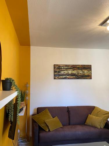 a living room with a couch and a painting on the wall at Château, poteries, vins et randonnées 2 in Saint-Amand-en-Puisaye