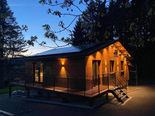 a wooden house with lights on it at night at La Roanneuse - Cosy Chalet in Francorchamps