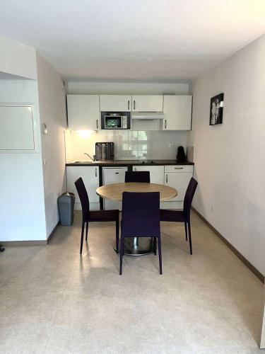 une cuisine avec une table et des chaises dans une pièce dans l'établissement Résidence Balcon Du Canigou - T2 dans la résidence Les Balcons du Canigou MAE-2781, à Vernet-les-Bains