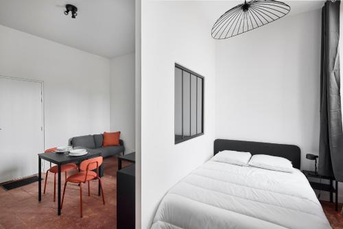 une chambre avec un lit et une table avec une chaise dans l'établissement West Side Story - Wifi ,City center, à Beaupréau