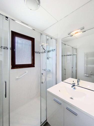 une salle de bain blanche avec une douche et un lavabo dans l'établissement Résidence Het Club - Charmante maison avec jardin dans la pinède pour 6 personnes à Lacanau Océan MAE-0401, à Lacanau