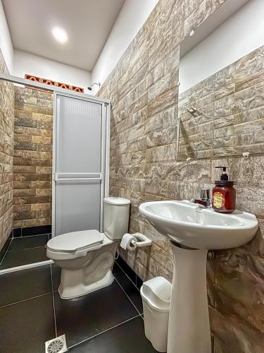 a bathroom with a toilet and a sink at Hotel Casa Madrid in Puerto Berrío