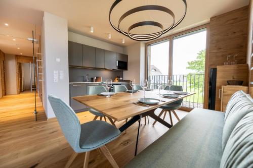 a dining room and kitchen with a wooden table and chairs at Ferienwohnungen Fasching - Ferienapartments Weitblick in Fischbach