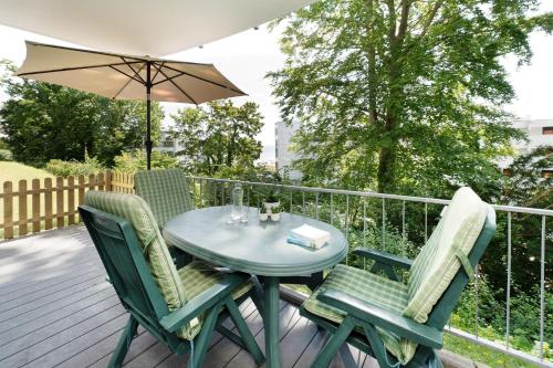 a table and chairs on a deck with an umbrella at Residenz am Yachthafen- Ostseeblüte in Grömitz