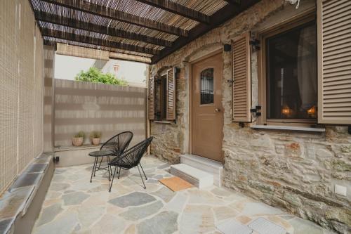 a patio with two chairs and a table and a door at Theros in Karistos