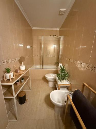 ein Badezimmer mit 2 WCs, einer Badewanne und einem Waschbecken in der Unterkunft Casa Soleme San Juan de Los terreros in San Juan de los Terreros