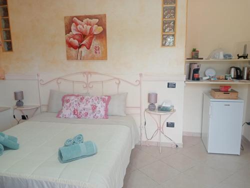 a bedroom with a white bed with two blue towels on it at M'arriposu in Realmonte