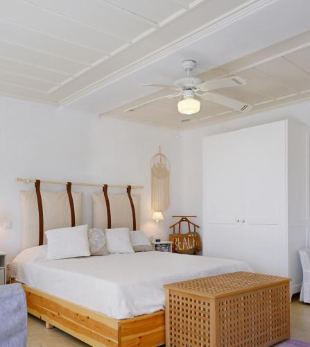a bedroom with a bed and a ceiling fan at Kanala Sea-Side Cycladic Cottage I in Kanala