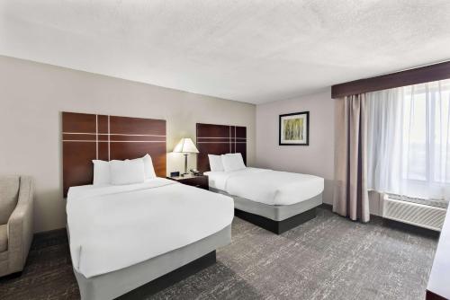 a hotel room with two beds and a window at Best Western Luxbury Inn Fort Wayne in Fort Wayne