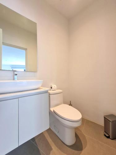 a bathroom with a white toilet and a sink at Lesplanade By Wynwood House in Panama City