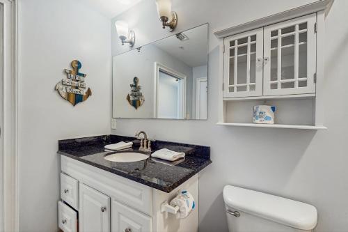 a bathroom with a sink and a mirror and a toilet at The Indies #306 in Fort Morgan