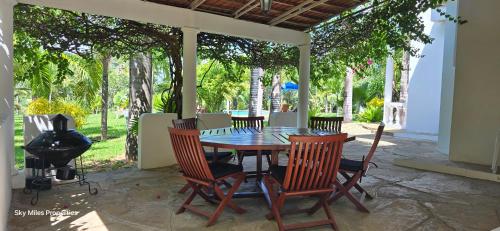 a patio with a table and chairs and a grill at Jasmin Villa in Mtwapa