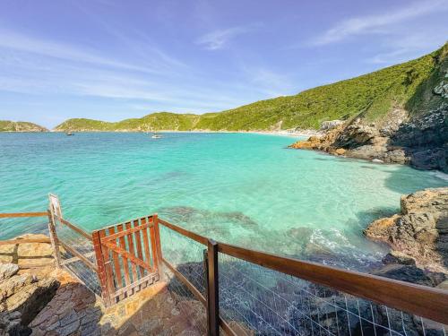a view of a beach with a fence and the water at Hotel Recanto do Atalaia in Arraial do Cabo