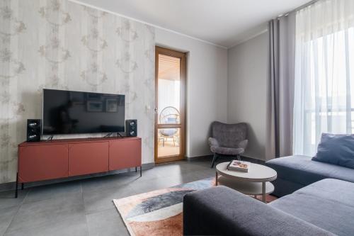 un soggiorno con un divano e una televisione di Apartamenty Olimpic a Kołobrzeg