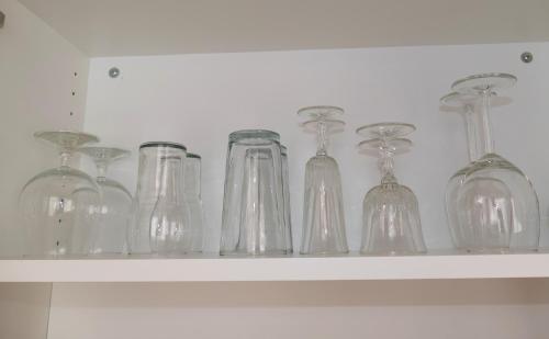 a shelf with glass bottles and glasses on it at City Apartmentstudio mit Tiefgarage free parking in Graz