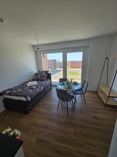 a bedroom with a bed and a table with chairs at Stilvolle Neubauwohnung mit Balkon&WLAN in Hannover