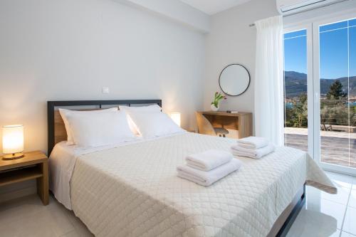 a bedroom with a white bed with towels on it at Theros Apartment 1 in Yénion