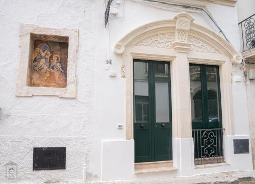 a building with a green door and a painting at Mesciu Bruno Casa Vacanza in Copertino