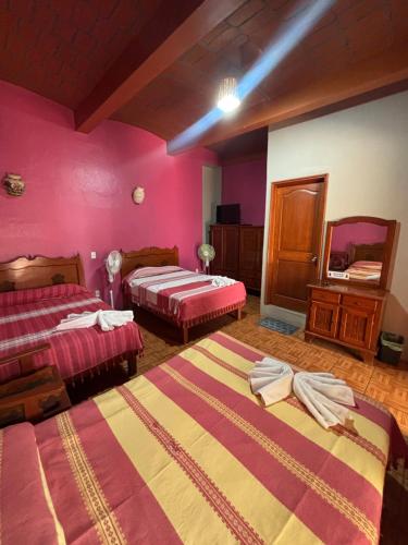 a hotel room with two beds and a mirror at Hotel Posada "Mi Rosita" in Oaxaca City