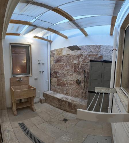 a bathroom with a sink and a stone wall at Mesciu Bruno Casa Vacanza in Copertino