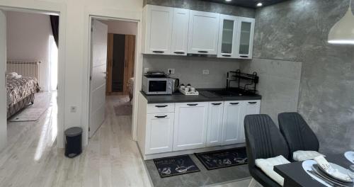 a kitchen with white cabinets and a microwave at Apartman Manda in Belgrade