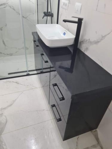a bathroom with a sink on a black counter at Topfix in Korçë