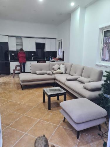 a living room with couches and a person in a kitchen at Topfix in Korçë