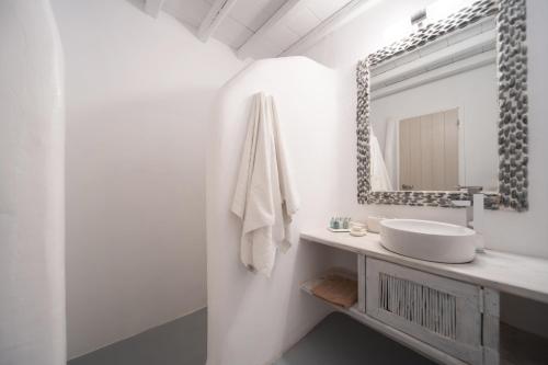 a white bathroom with a sink and a mirror at Villa ANASA private Pool & Jacuzzi 8pax at Panormos in Panormos Mykonos