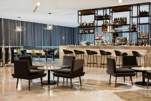 a restaurant with tables and chairs and a bar at AC Hotel by Marriott Guadalajara Mexico in Guadalajara