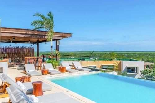a villa with a swimming pool and a patio at Aloft Tulum in Tulum