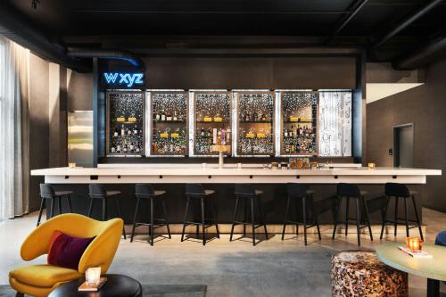 a bar at the wxyz nightclub with bar stools at Aloft Lawrenceville Sugarloaf in Lawrenceville