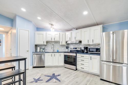 a kitchen with white cabinets and stainless steel appliances at Golf and Pool Access Home with Yard in Lady Lake in Lady Lake