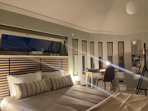 a bedroom with a bed and a desk and a television at BestHomeStay- Estoril in Estoril