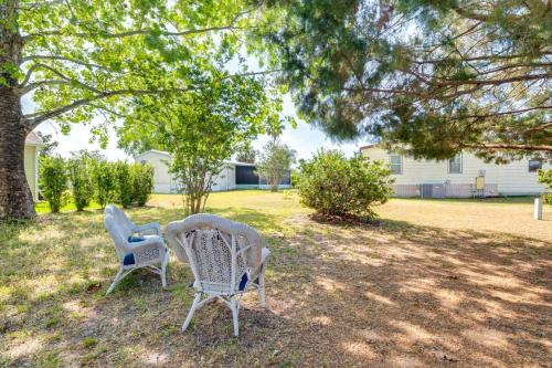 two chairs sitting in a yard under a tree at Golf and Pool Access Home with Yard in Lady Lake in Lady Lake