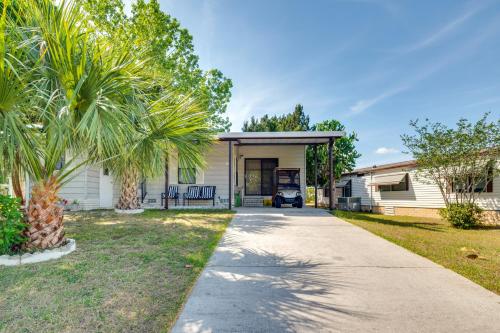 a house with a palm tree and a driveway at Golf and Pool Access Home with Yard in Lady Lake in Lady Lake
