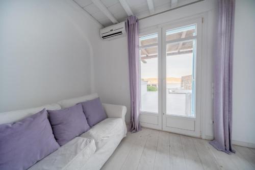a living room with a couch and a window at Villa ANASA private Pool & Jacuzzi 8pax at Panormos in Panormos Mykonos