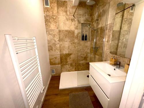 une salle de bain avec un lavabo et une douche dans l'établissement La Douce Escale, à Rouen