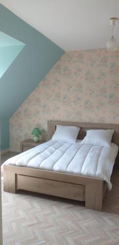 a large bed in a room with a wall at Le logis Dan'Laur in Maen Roch