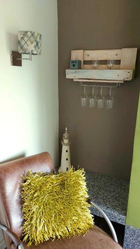a room with a leather chair and a shelf with wine glasses at Vakantiehuis Jade in Bruinisse