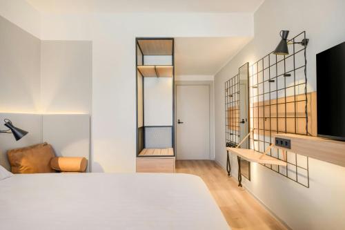 a bedroom with a bed and a living room at Moxy Pompeii in Torre Annunziata