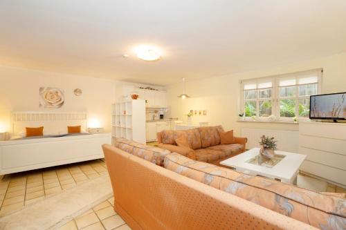 a living room with a couch and a tv at Erlenstübchen in Scharbeutz