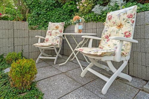two chairs and a table on a patio at Erlenstübchen in Scharbeutz